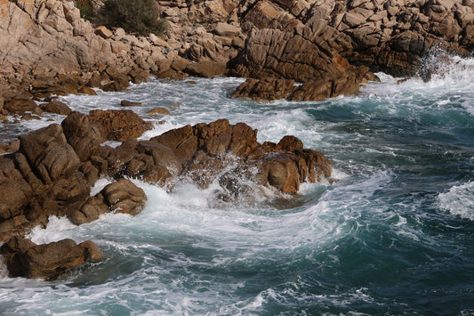 Stunning rocky shoreline with waves crashing against the cliffs, showcasing the beauty of the ocean.