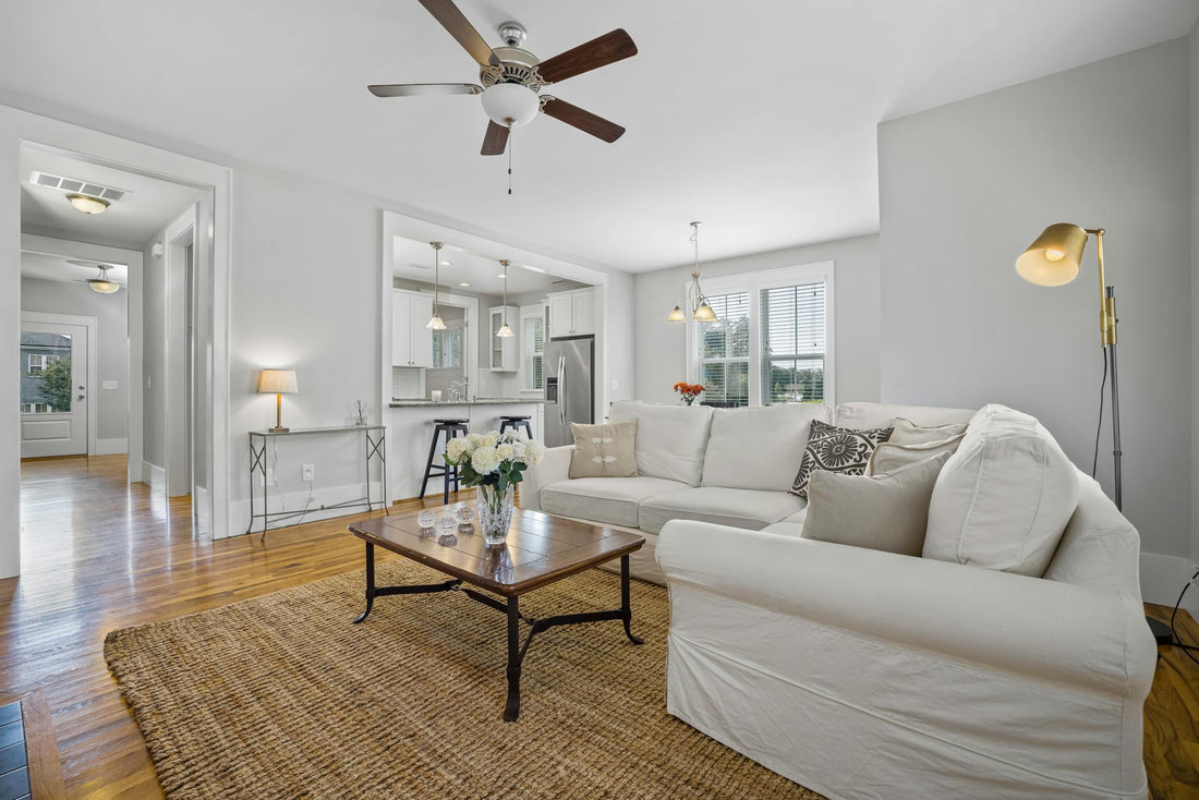 Spacious living room with a sofa set, ceiling fan, and elegant decor.