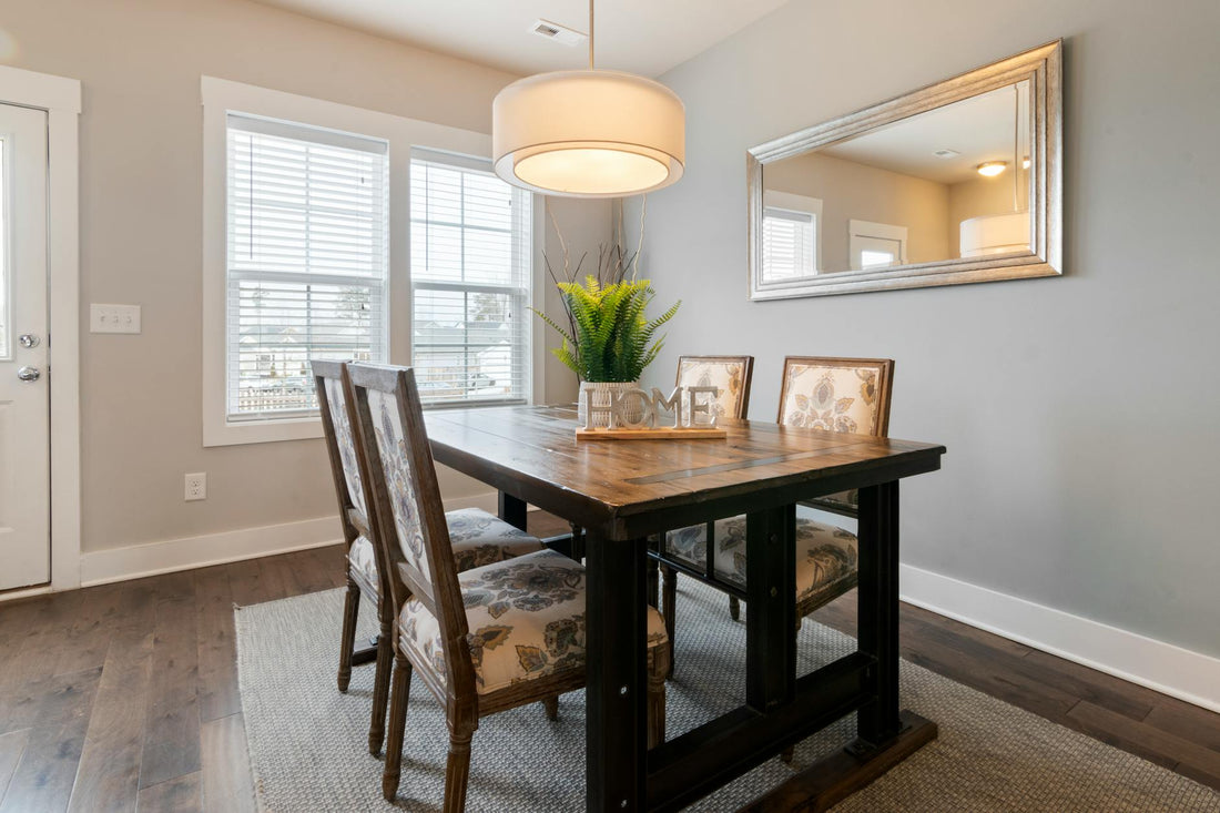 Bright and airy dining room featuring wooden table, floral chairs, and modern lighting.
