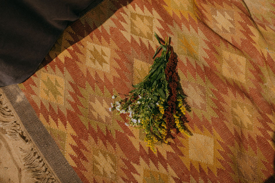 A vibrant floral bouquet on a bohemian patterned rug, exuding a warm, natural vibe.