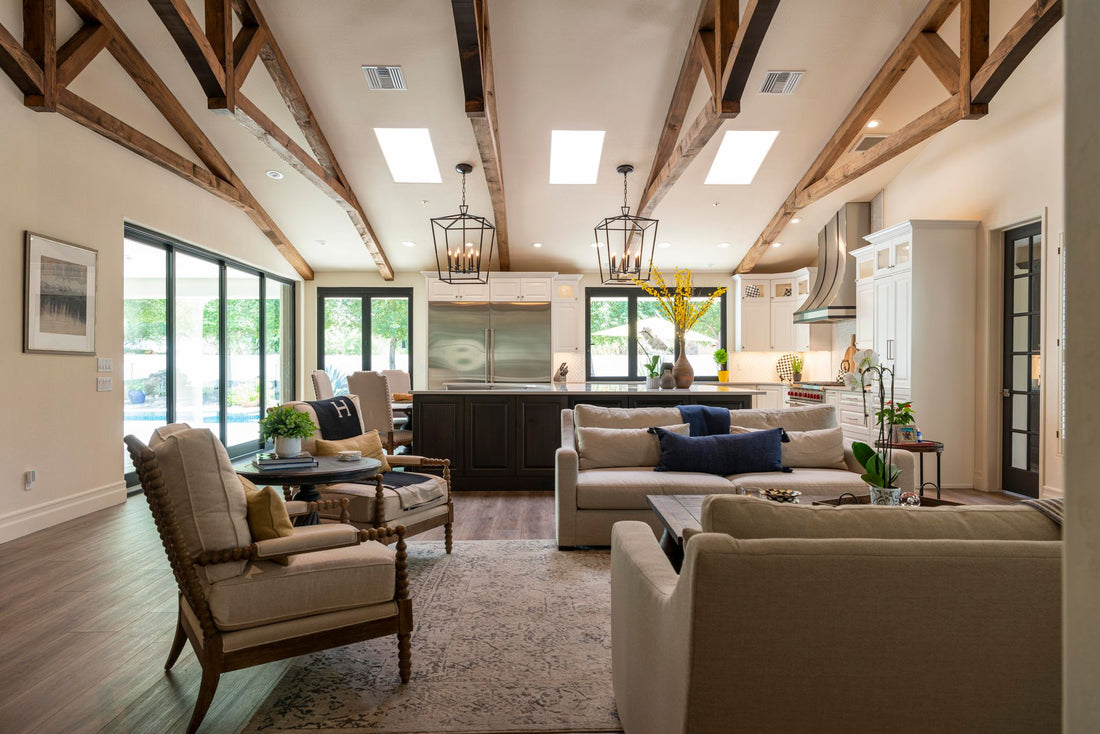 Spacious open-plan living room and kitchen with modern furnishings and wooden beams.