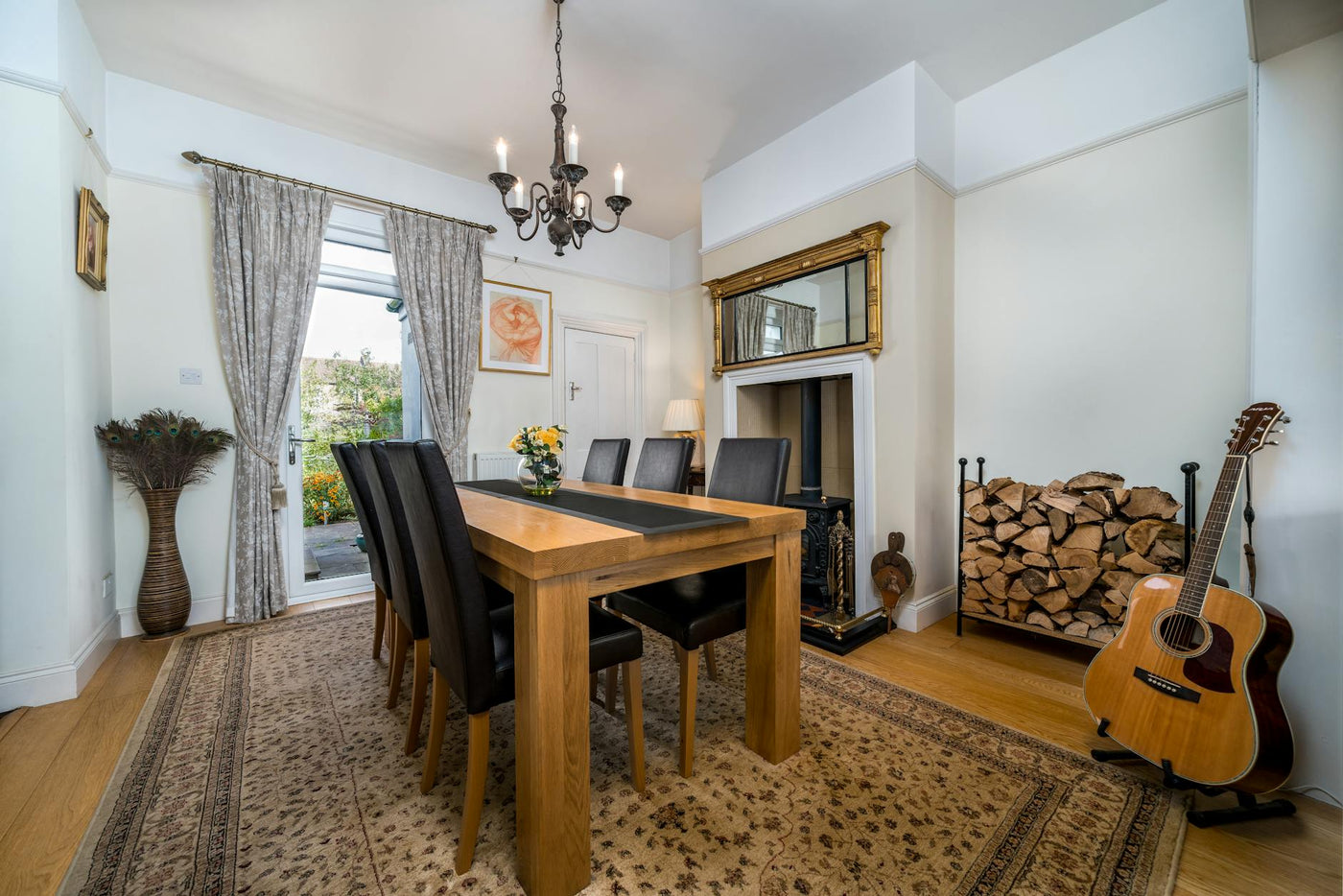 Beautifully designed dining room featuring classic furniture and a guitar by the fireplace.