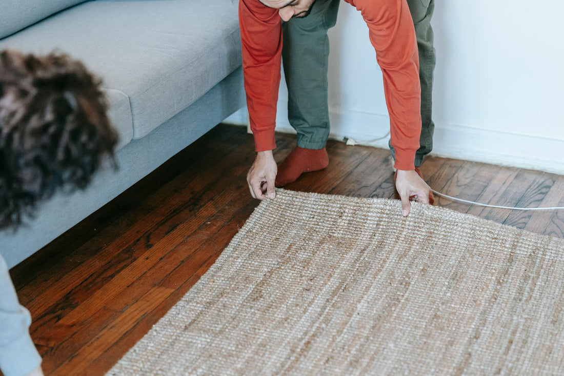 A couple arranging a carpet in a cozy living room, creating a warm home atmosphere.