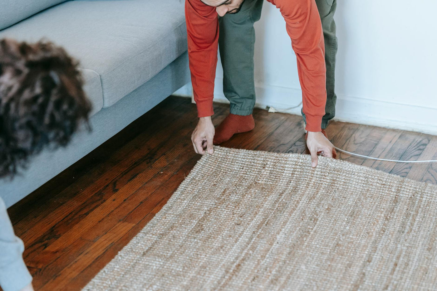 A couple arranging a carpet in a cozy living room, creating a warm home atmosphere.