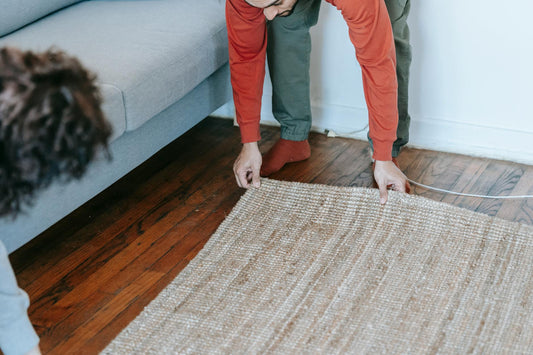 A couple arranging a carpet in a cozy living room, creating a warm home atmosphere.