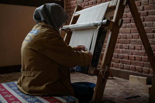Skilled artisan weaving in a traditional Bursa workshop, showcasing manual work craftsmanship.