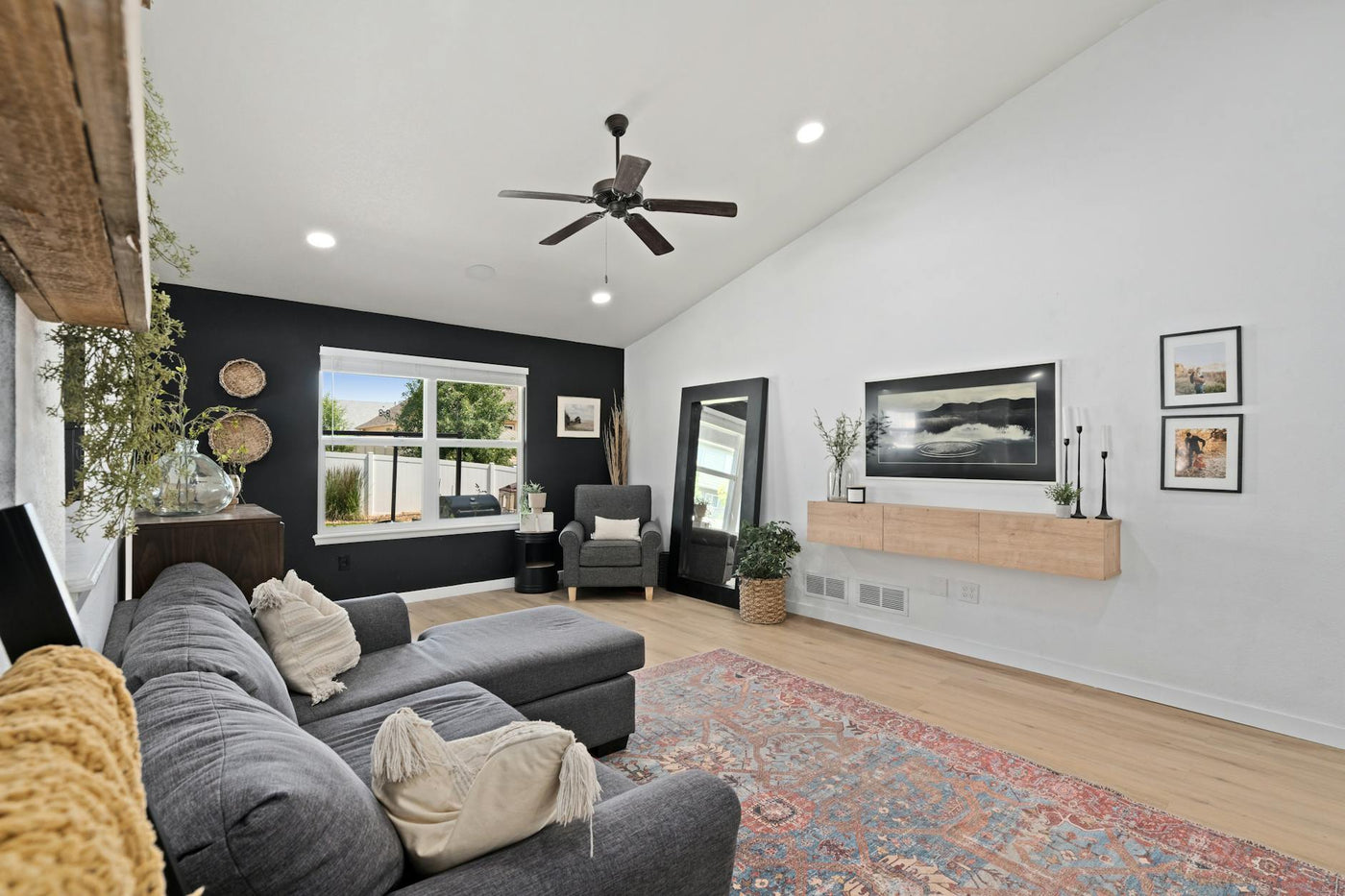 A stylish and cozy modern living room featuring a sectional couch, decorative elements, and natural light through large windows.