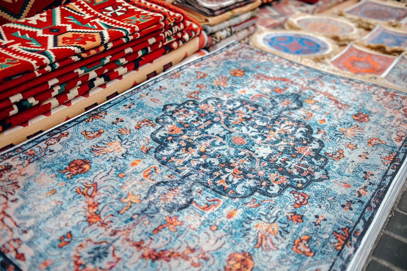 A collection of traditional handmade carpets with vibrant patterns on display.