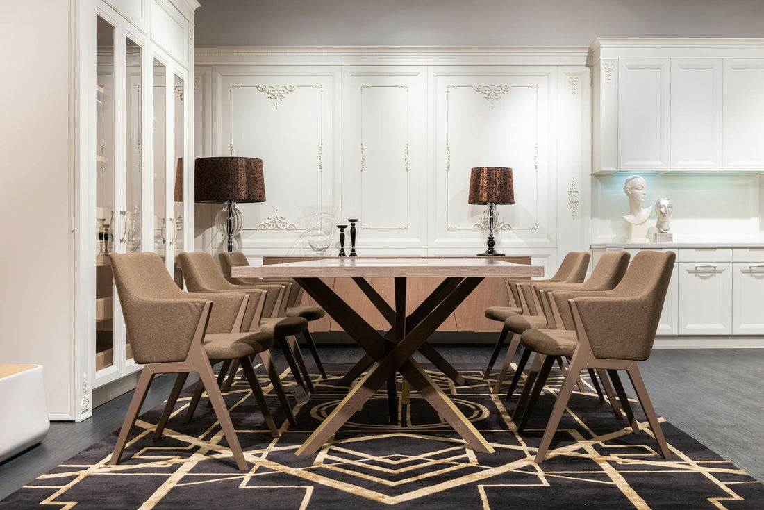 Contemporary table with set of chairs placed on rug in spacious kitchen with white cupboards and classic design at home