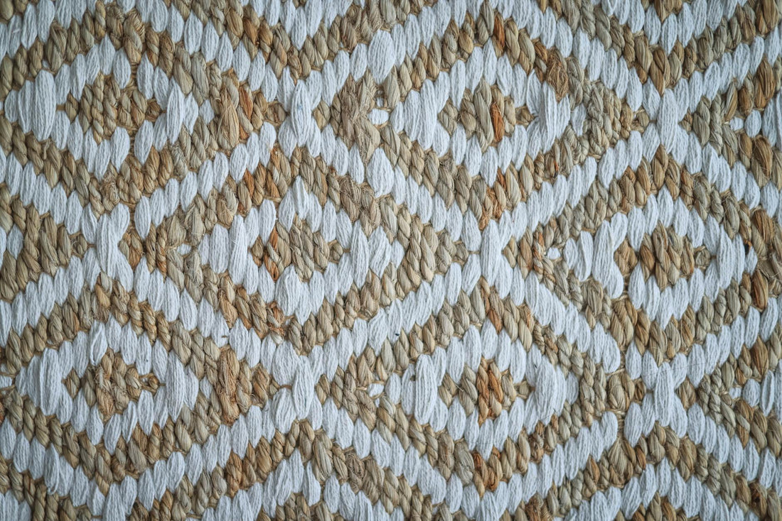 Detailed view of a woven rug with a beige and white geometric pattern.