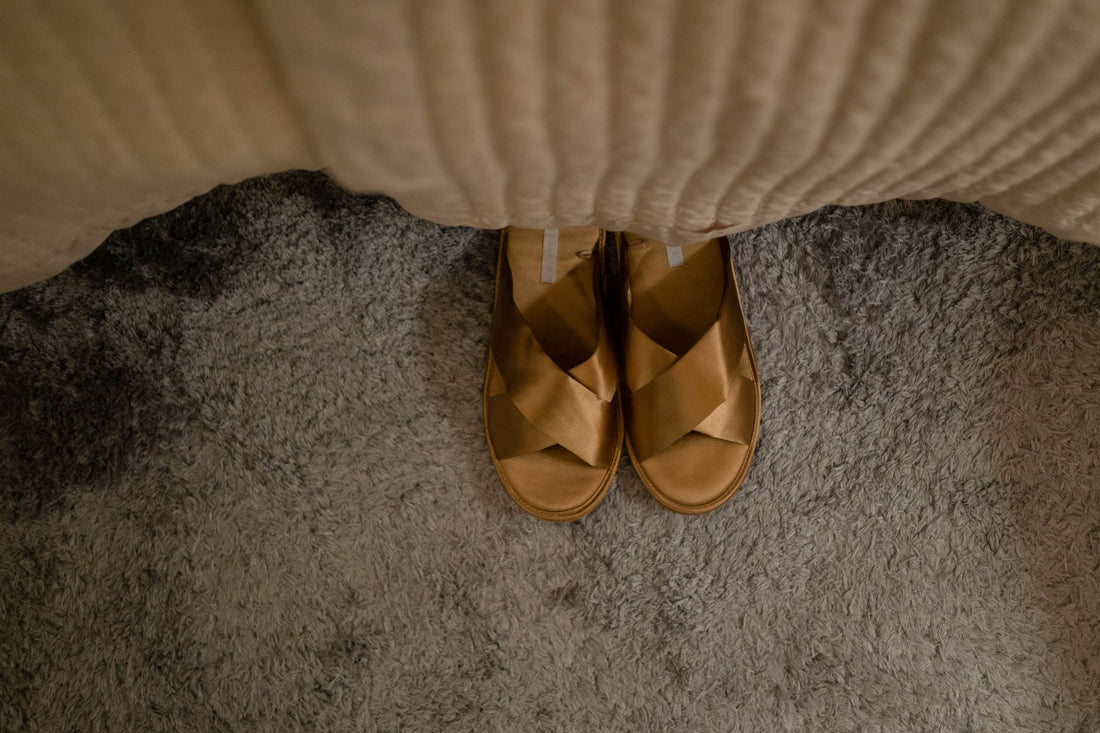 A pair of cozy sandals on a textured carpet, creating a warm indoor vibe.