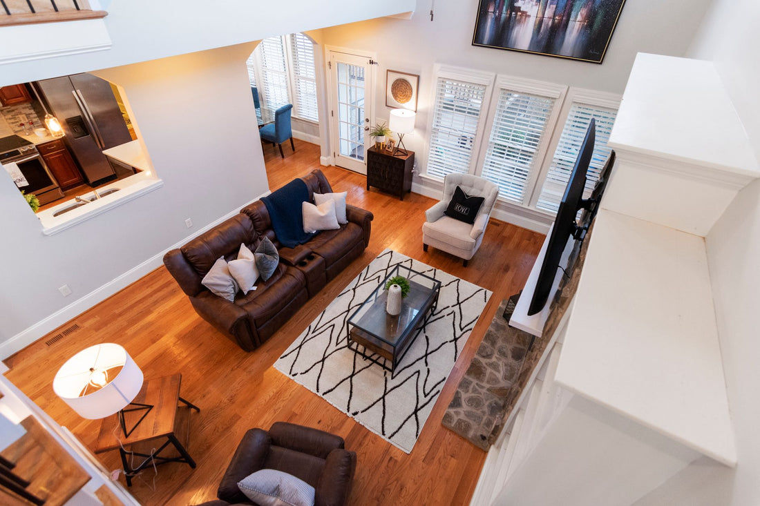 Elegant living room with leather sofas, soft lighting, and modern decor viewed from above.