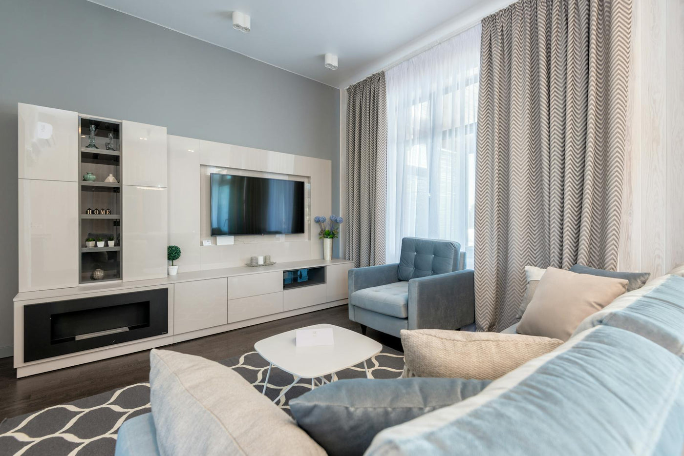 Stylish contemporary living room interior with modern furniture and blue accents.