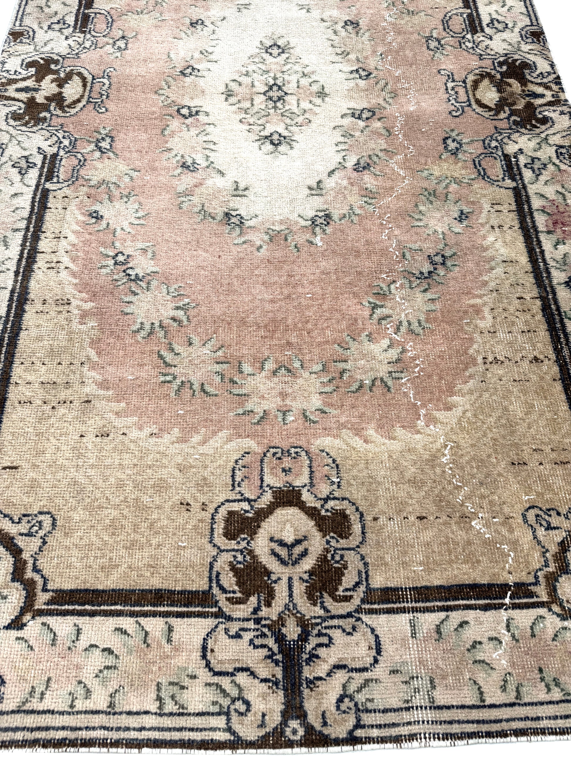 Corner detail of the Artisan Angelina Lt. Gold rug showing authentic vintage distressing