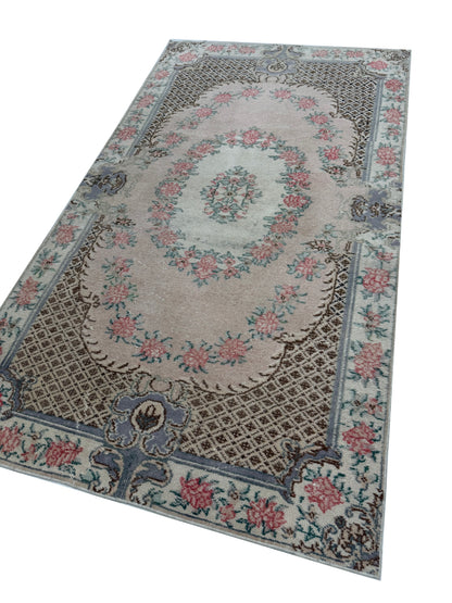 Close-up detail of the hand-knotted wool texture on the Artisan Angelina Coral rug
