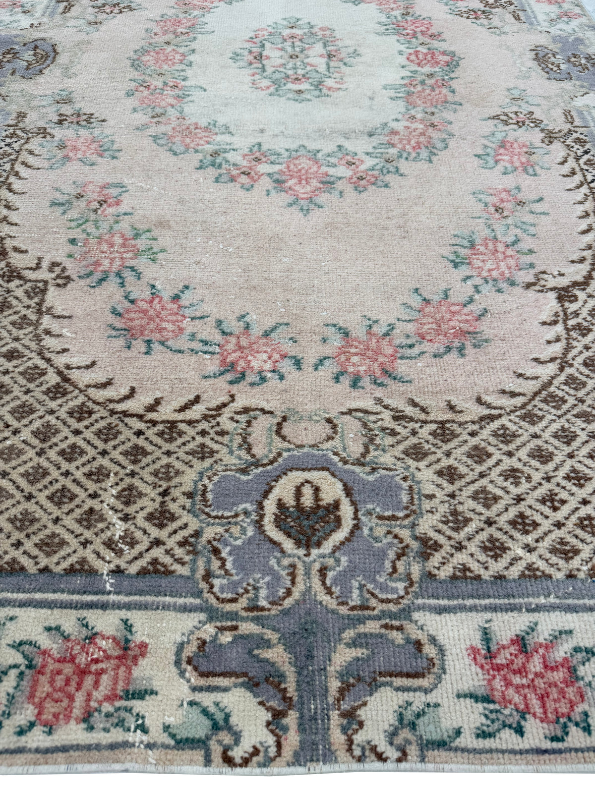 Corner view of the Artisan Angelina Coral rug displaying authentic aged fringe and weave