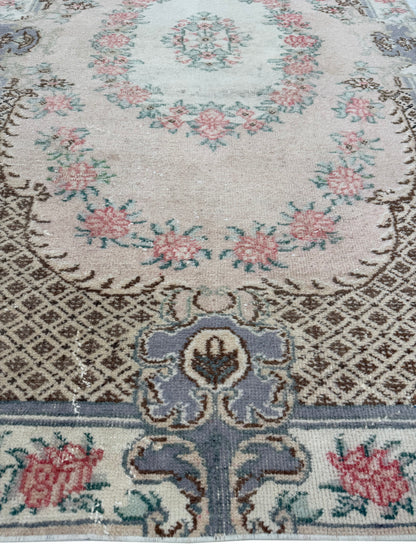 Corner view of the Artisan Angelina Coral rug displaying authentic aged fringe and weave