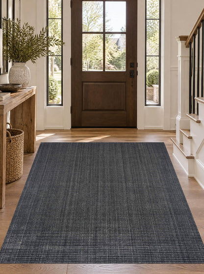 Artisan Carey Charcoal Style Shot — Charcoal rug with fine linear texture in a sunlit entryway.