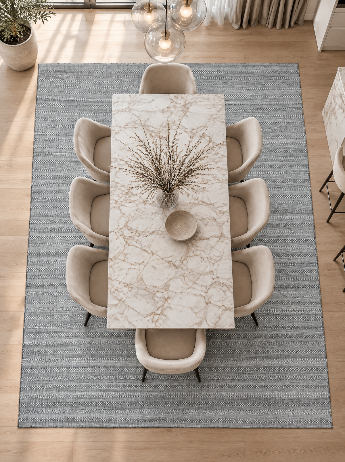 Artisan Eco Weave Grey Dining Room Overhead Shot — Overhead view of a textured grey area rug beneath a marble dining table and cream chairs.