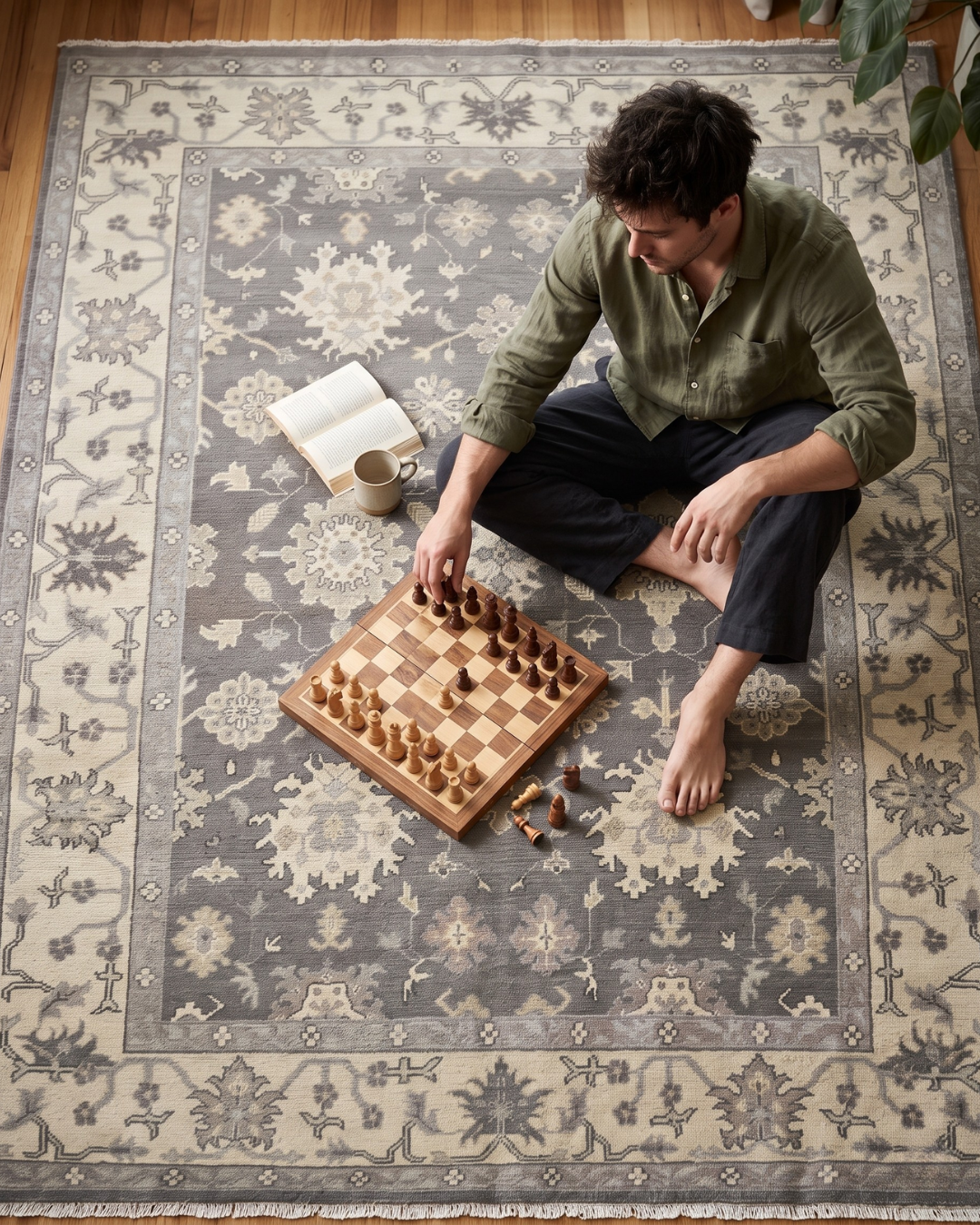 Artisan Emma Pewter Beige Style Shot — Pewter and beige floral rug beneath a man playing chess.