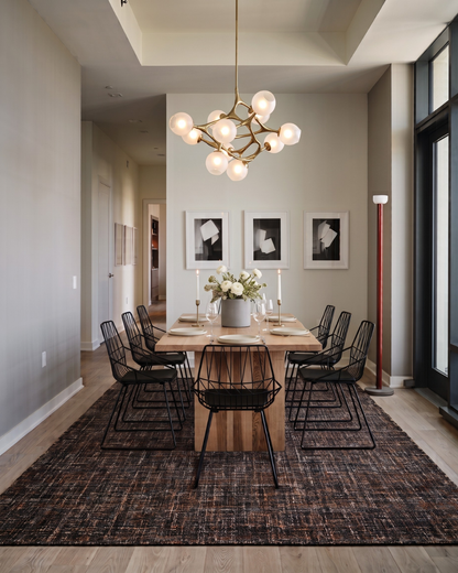 Dalyn Rugs Abruzzo AZ1 Black Dining Room Shot — Black area rug beneath a wood dining table.
