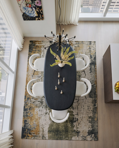 Dalyn Rugs Kochi KC14 Putty Dining Room Overhead Shot — Overhead view of a putty, olive, and gold abstract area rug beneath a black dining table.