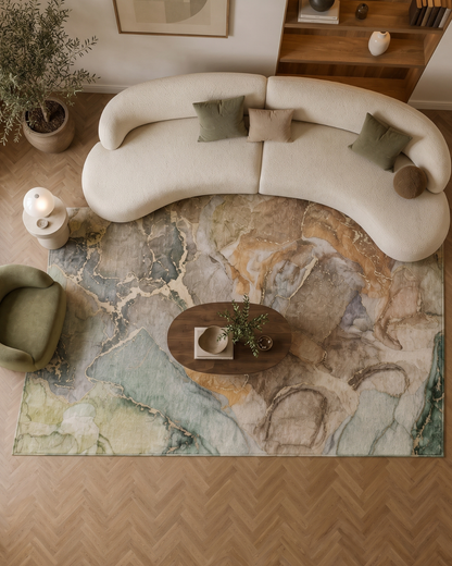 OY1 Taupe Overhead: Taupe abstract rug beneath a curved sofa.