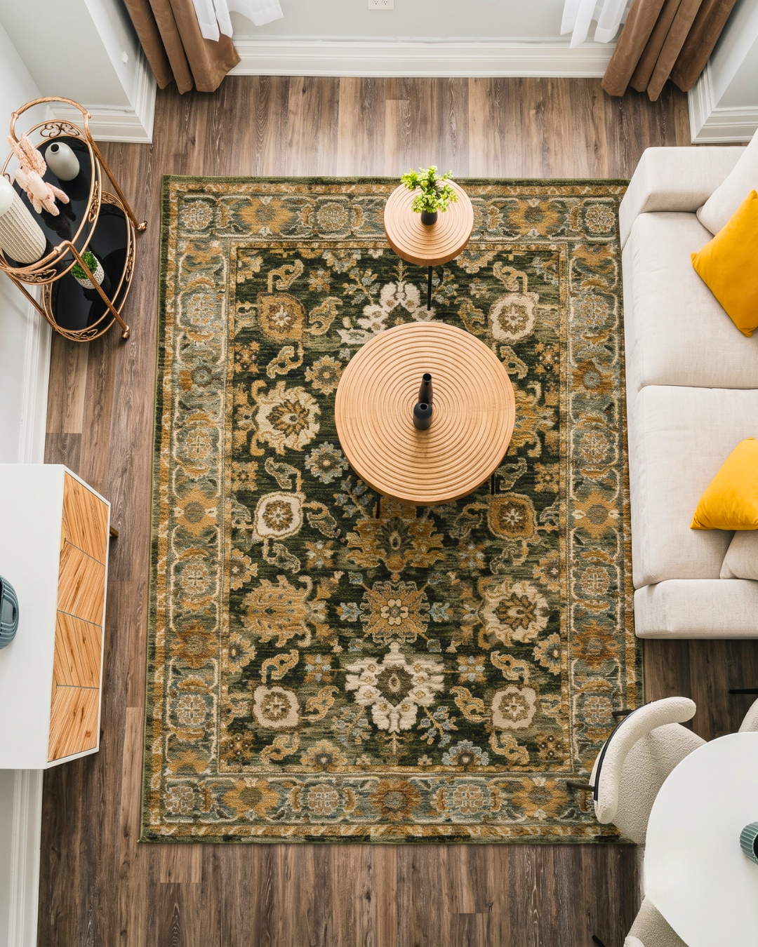 Oriental Weavers Andorra 2417B Green Gold traditional rug in a modern living room overhead view.