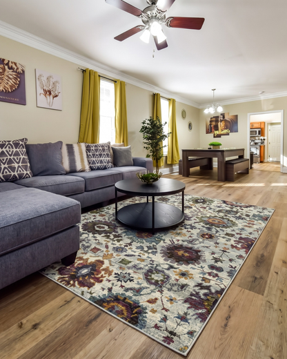 Oriental Weavers Andorra 7129A Stone Multi traditional floral rug styled in a cozy living room.