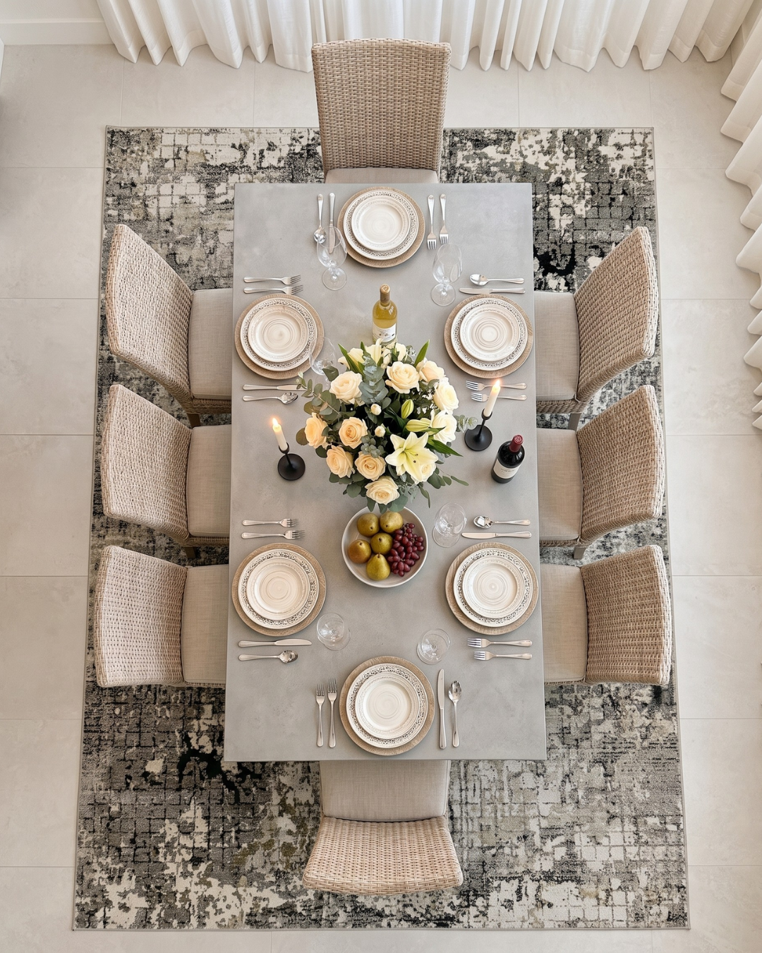 Oriental Weavers Nebulous 091D9 Grey Ivory Dining Room Overhead Shot — Grey and ivory abstract rug beneath an elegant dining table and woven chairs.